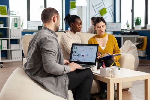 businessman-holding-laptop-with-financial-ghraphics-while-diverse-employees-talking (1).jpg