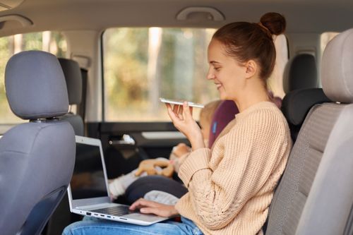 side-view-portrait-woman-working-laptop-using-voice-assistant-searchng-information-while-sitting-with-her-baby-daughter-safety-chair-backseat-car (1).jpg