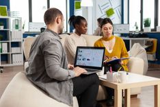 businessman-holding-laptop-with-financial-ghraphics-while-diverse-employees-talking (1).jpg